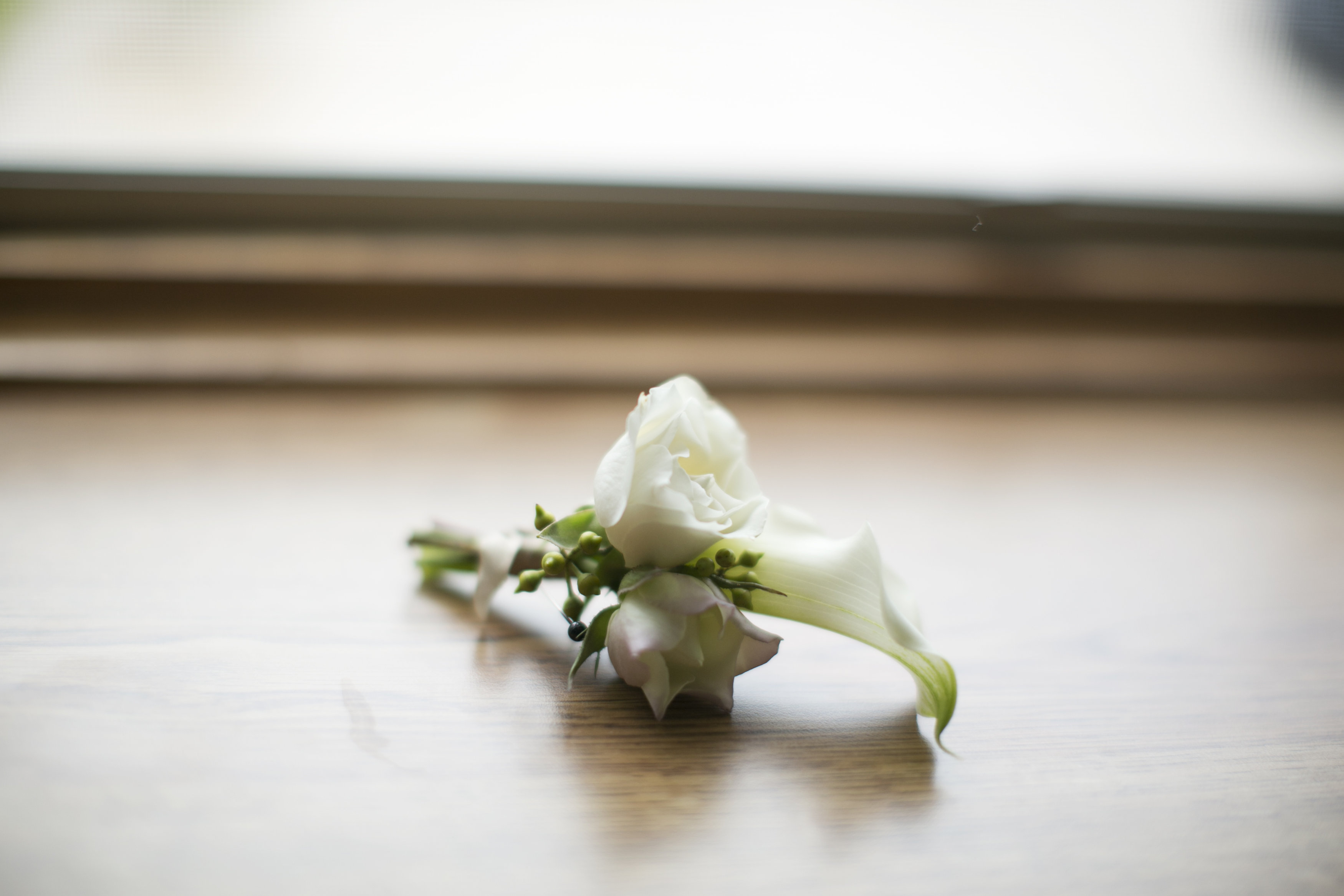 classic white boutonniere with spray rose and mini calla