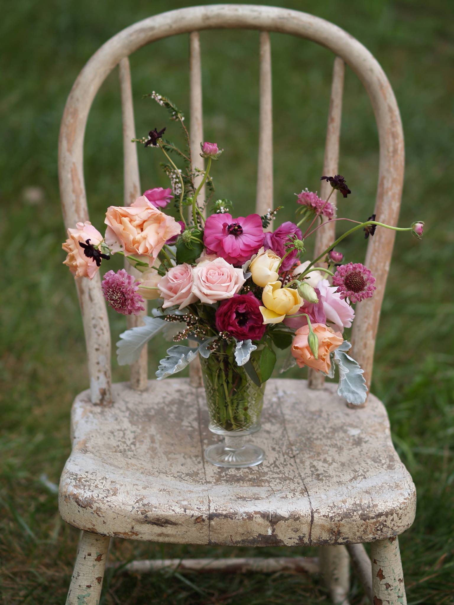 wild whimsical centerpiece in bright colors on old chipped paint chair